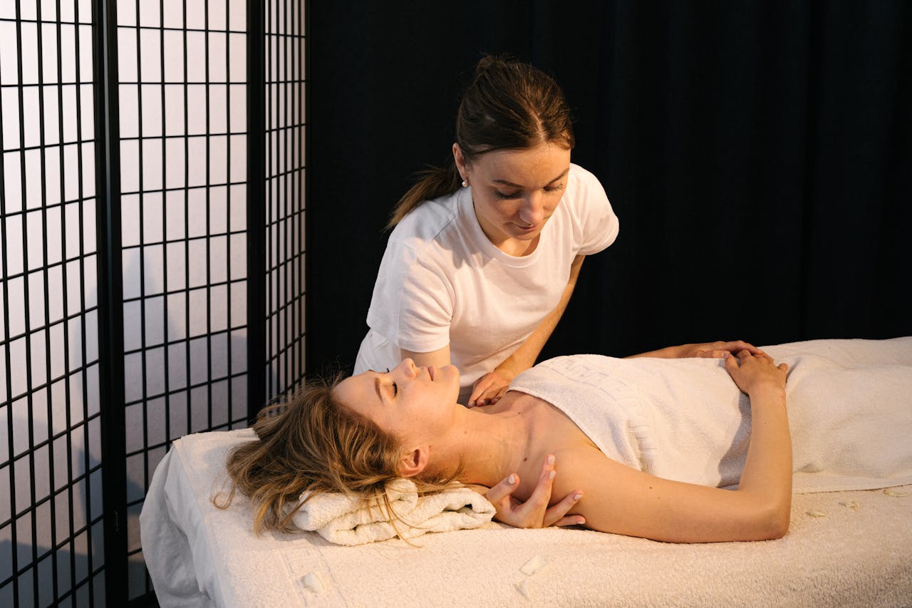 A Masseuse Massaging a Woman's Shoulder